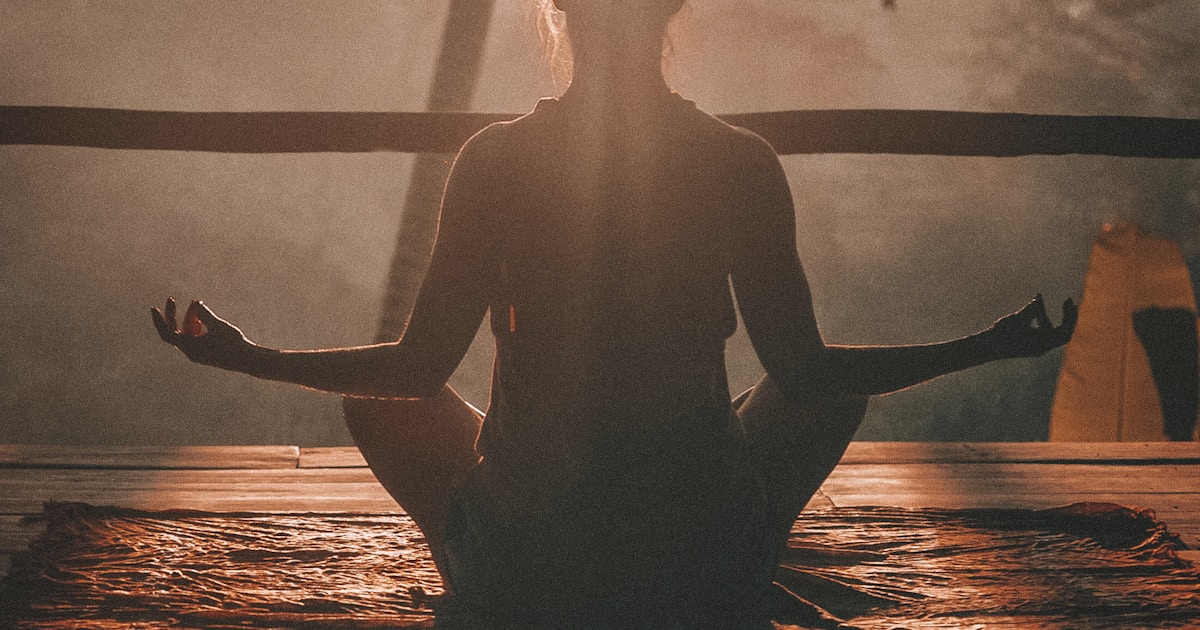 Woman meditating peacefully at sunrise